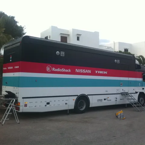 Truck eines Radsportteams mit Streifendesign in Rot und Türkis, 2012