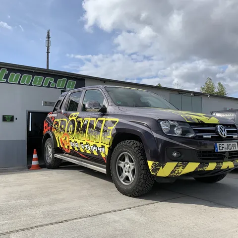 Schwarzer VW Amarok mit gelb-schwarzem Design vor der Werkstatt, 2019